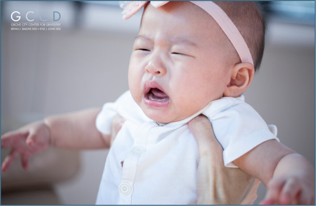 “Crying baby showing signs of discomfort, a common symptom of tongue-tie in infants, photographed during a dental consultation at Grove City Center for Dentistry.